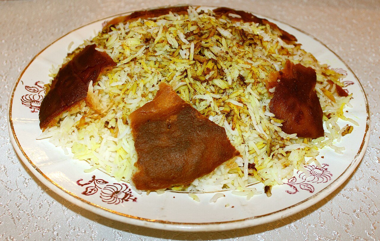 Azerbaijani plov — saffron-tinted rice topped with crisp qazmaq crust, served on a patterned plate