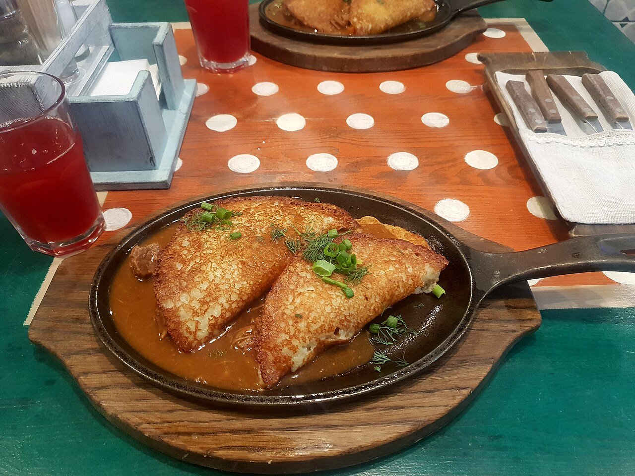 Belarusian draniki — crisp potato pancakes with beef goulash — served in a Minsk cafe