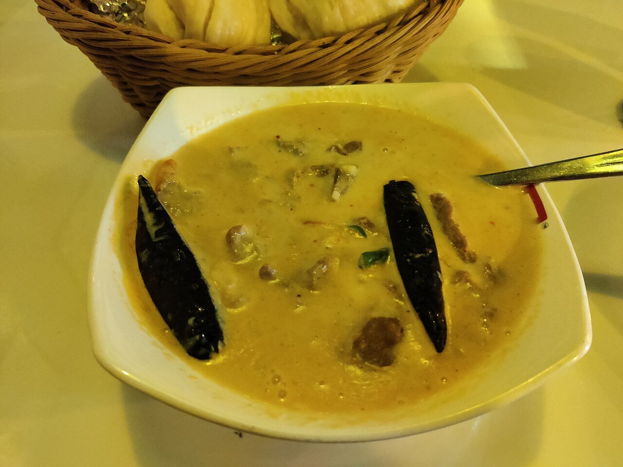 A bowl of ema datshi, Bhutan's national dish of chilies in yak cheese sauce, with bread