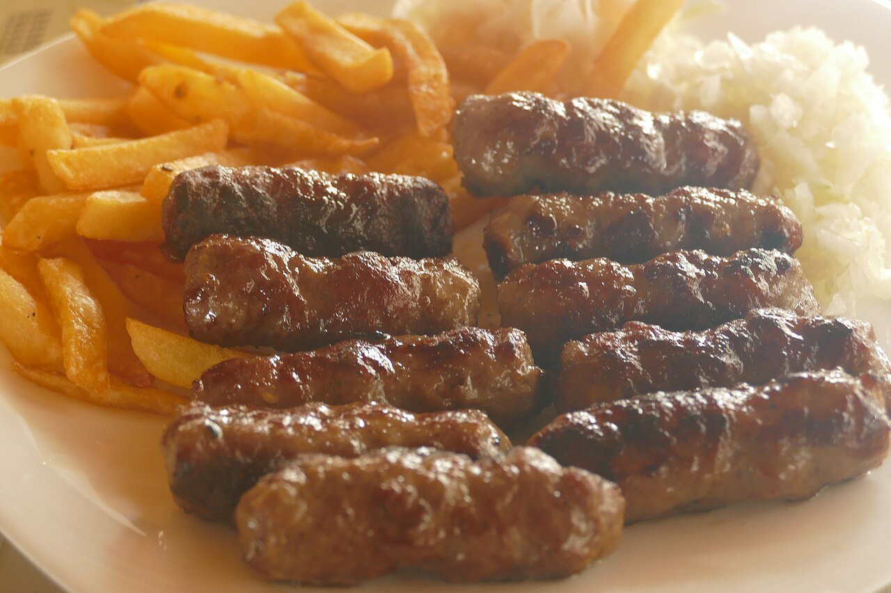 A plate of ćevapi — Bosnia's signature grilled minced-meat sausages — served with fries
