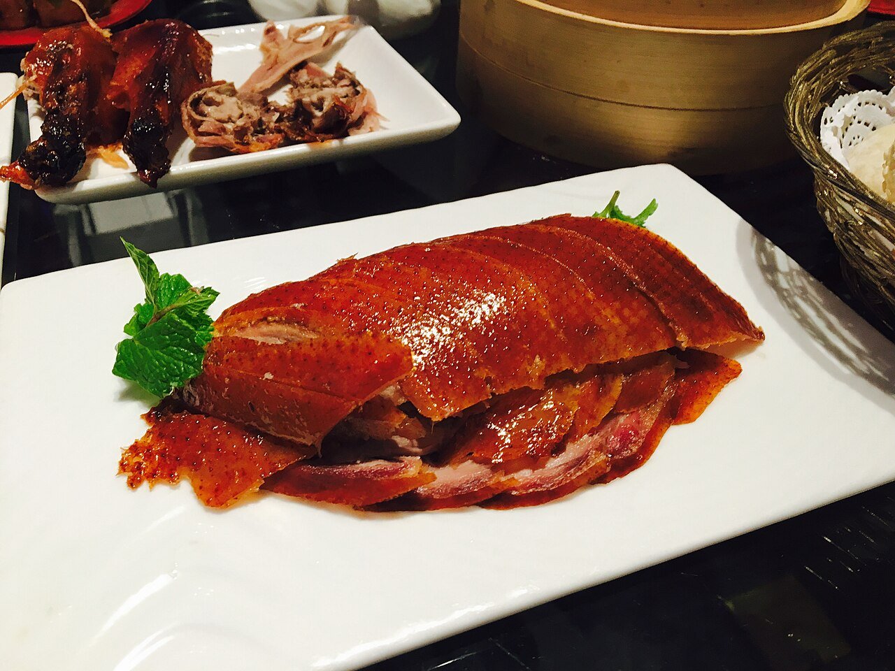 Sliced Peking duck with glossy lacquered skin on a white plate at a restaurant in China