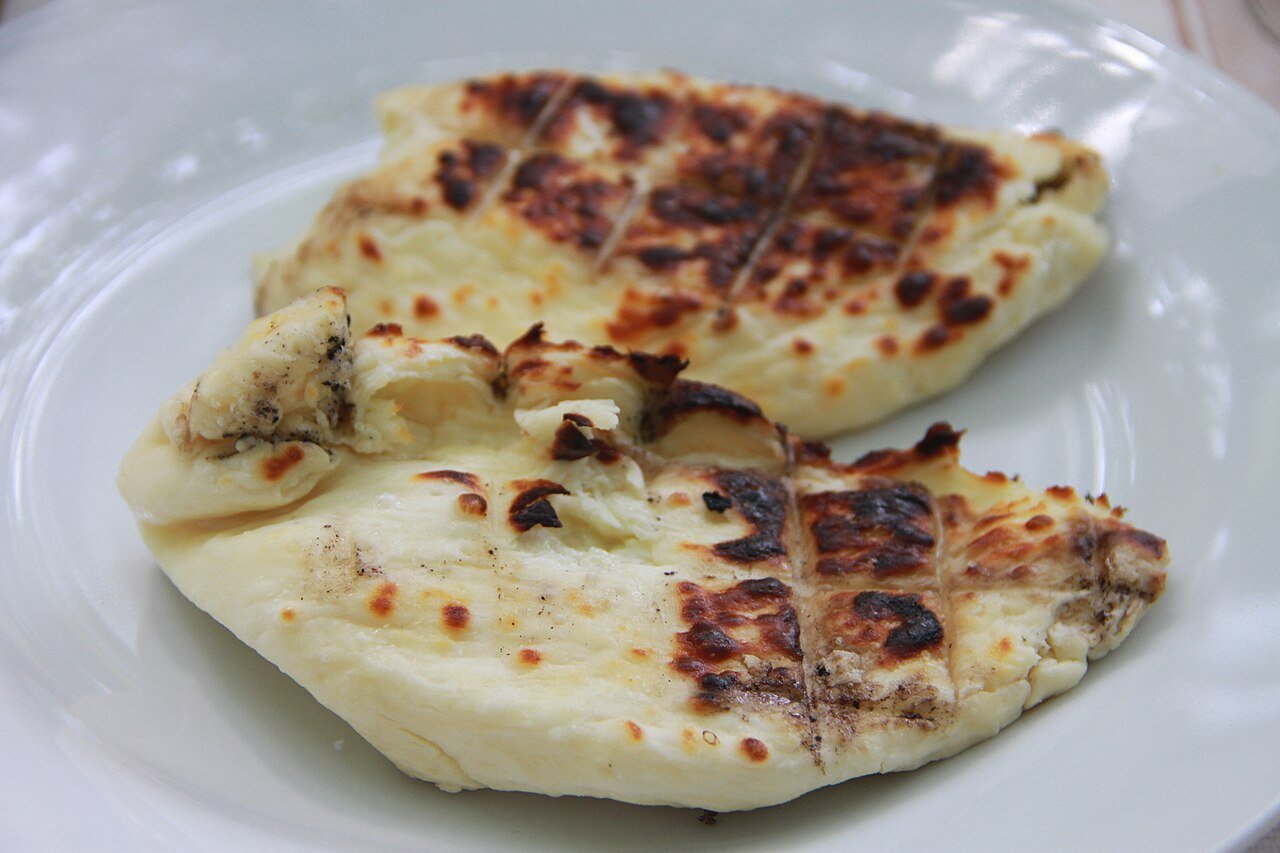 Two slices of grilled halloumi cheese with golden char marks, served on a plate in Cyprus