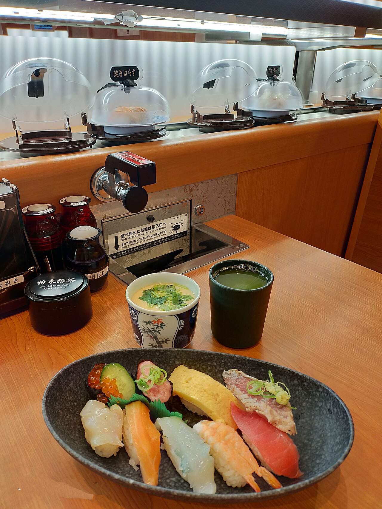 A plate of colorful nigiri sushi — salmon, tuna, shrimp and egg — at a conveyor-belt sushi restaurant in Japan