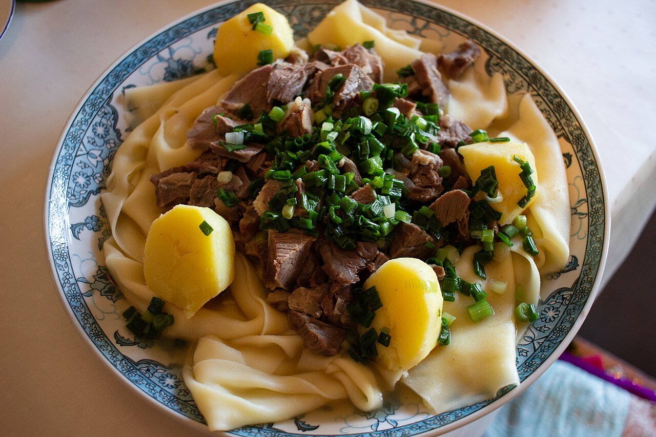 Beshbarmak — Kazakhstan's national dish of boiled meat over wide flat noodles, topped with greens and potatoes