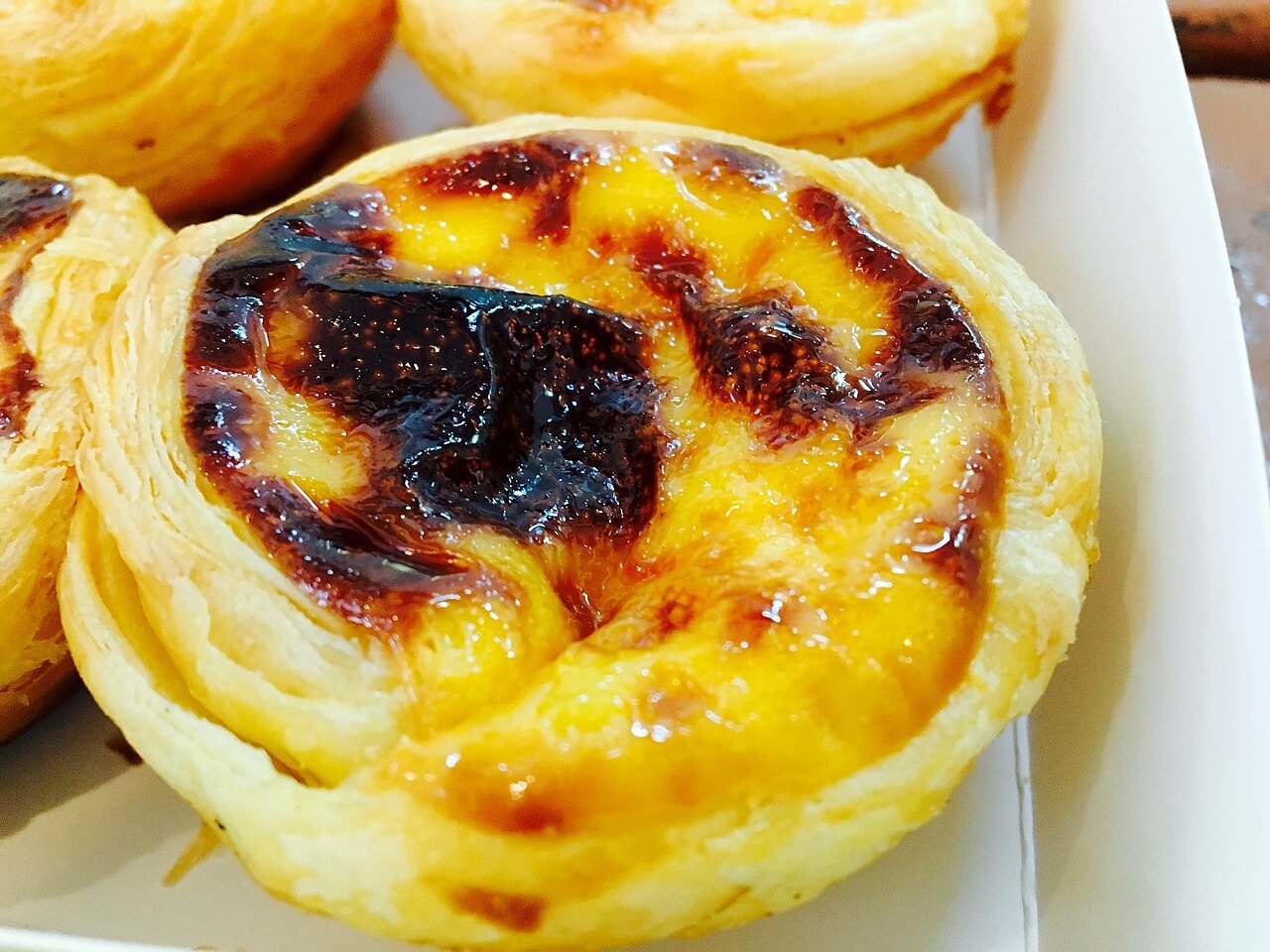 Golden pastéis de nata — Portuguese-style egg tarts with caramelized tops — Macau's signature pastry