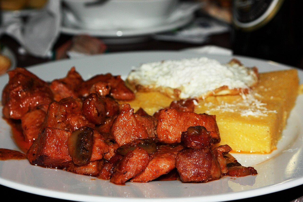 Moldovan tochitură — braised pork served with mămăligă, cheese, and a fried egg