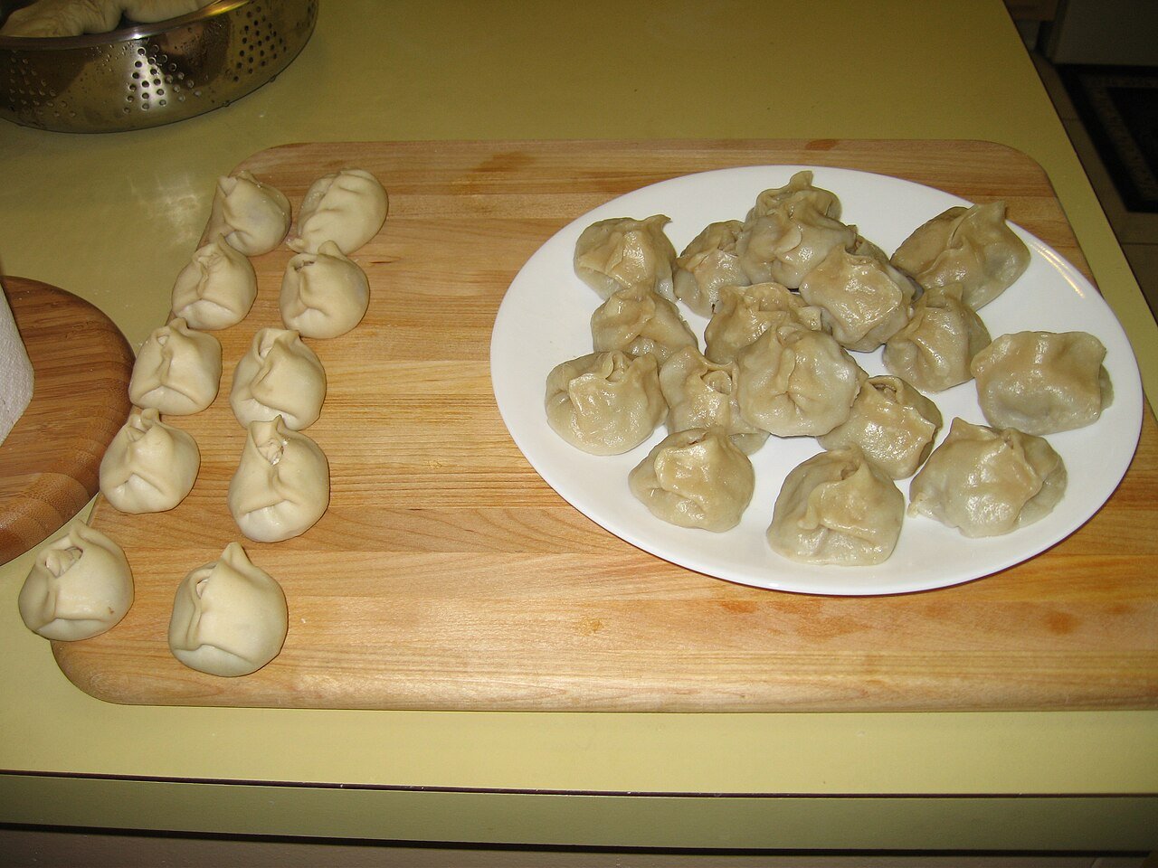 Mongolian buuz — steamed meat dumplings — cooked and uncooked on a plate