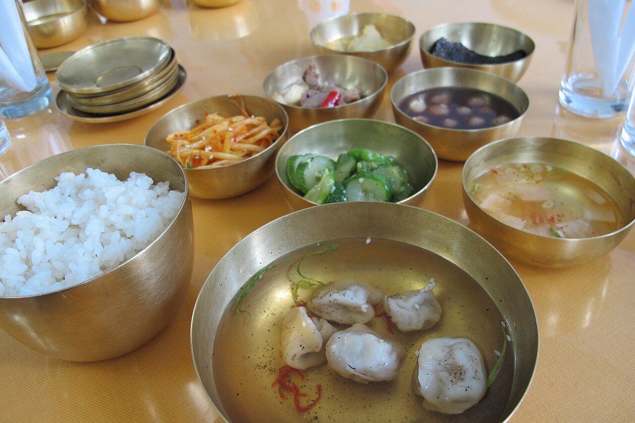 A North Korean meal spread with rice, dumplings, kimchi, and side dishes