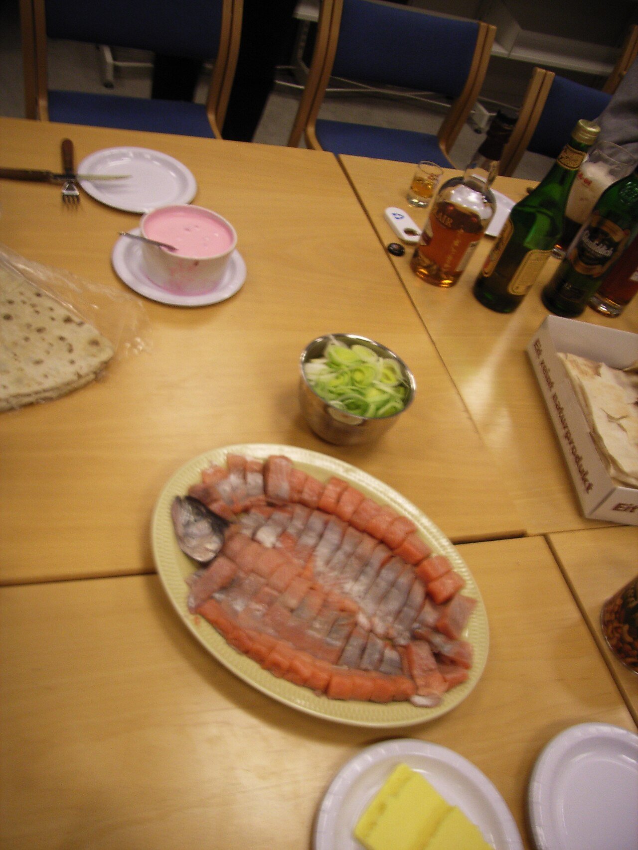 Sliced rakfisk — Norwegian fermented fish — on a platter with lefse and accompaniments