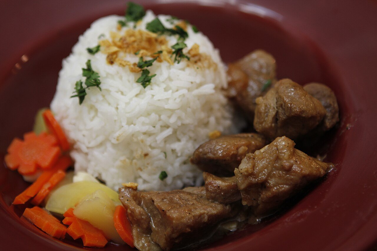 Pork adobo served with garlic rice (sinangag) and pickled vegetables