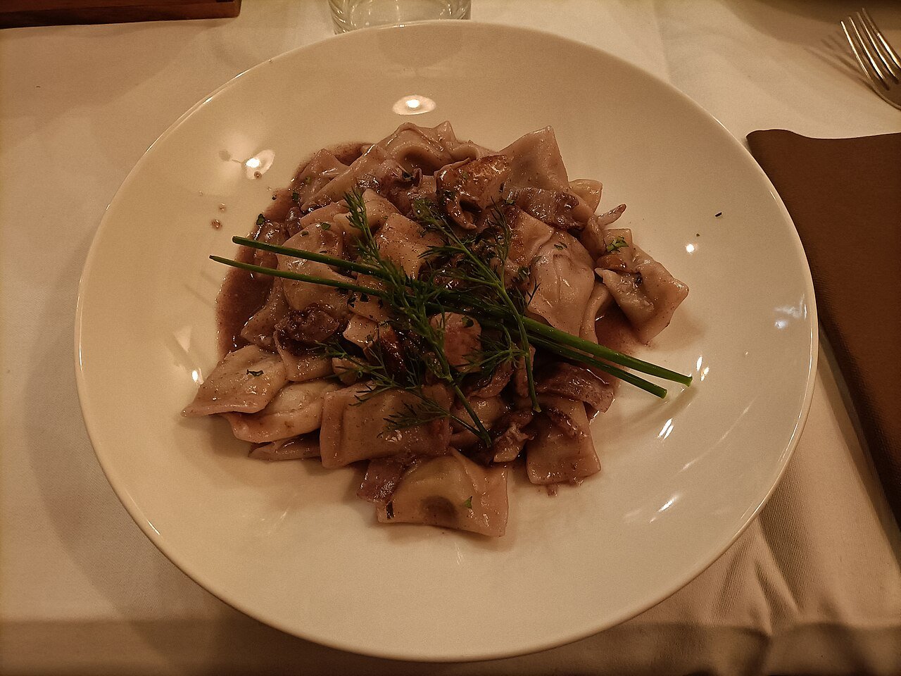 Idrijski žlikrofi — Slovenia's signature filled pasta dumplings from the Idrija region — plated with fresh herbs