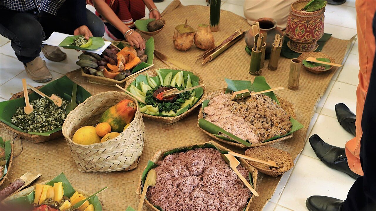 A traditional buffet of rice, vegetables, and fruit served in woven baskets in Viqueque, Timor-Leste