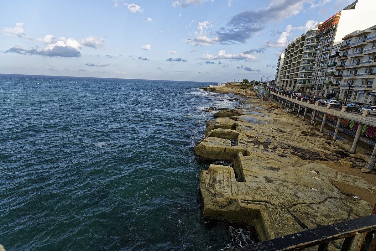 Sliema’s rocky seafront beside apartment buildings and the Mediterranean Sea, Malta