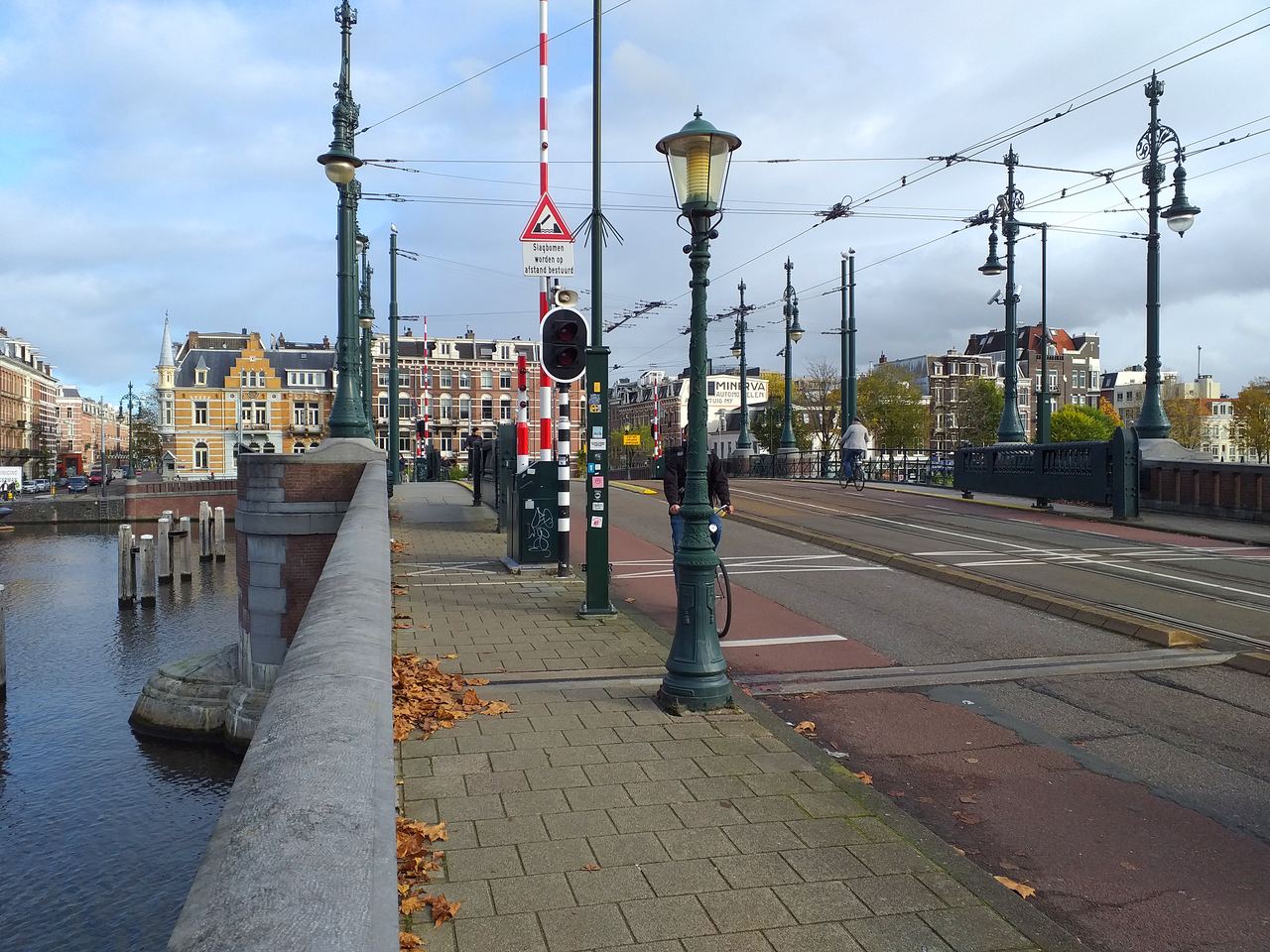 Cyclists cross the Nieuwe Amstelbrug bridge over a canal in Amsterdam, Netherlands