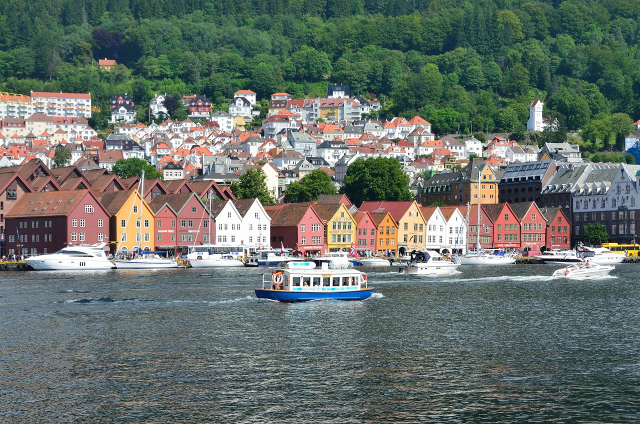 Colorful wooden wharf houses at Bryggen with boats in the harbour, Bergen, Norway