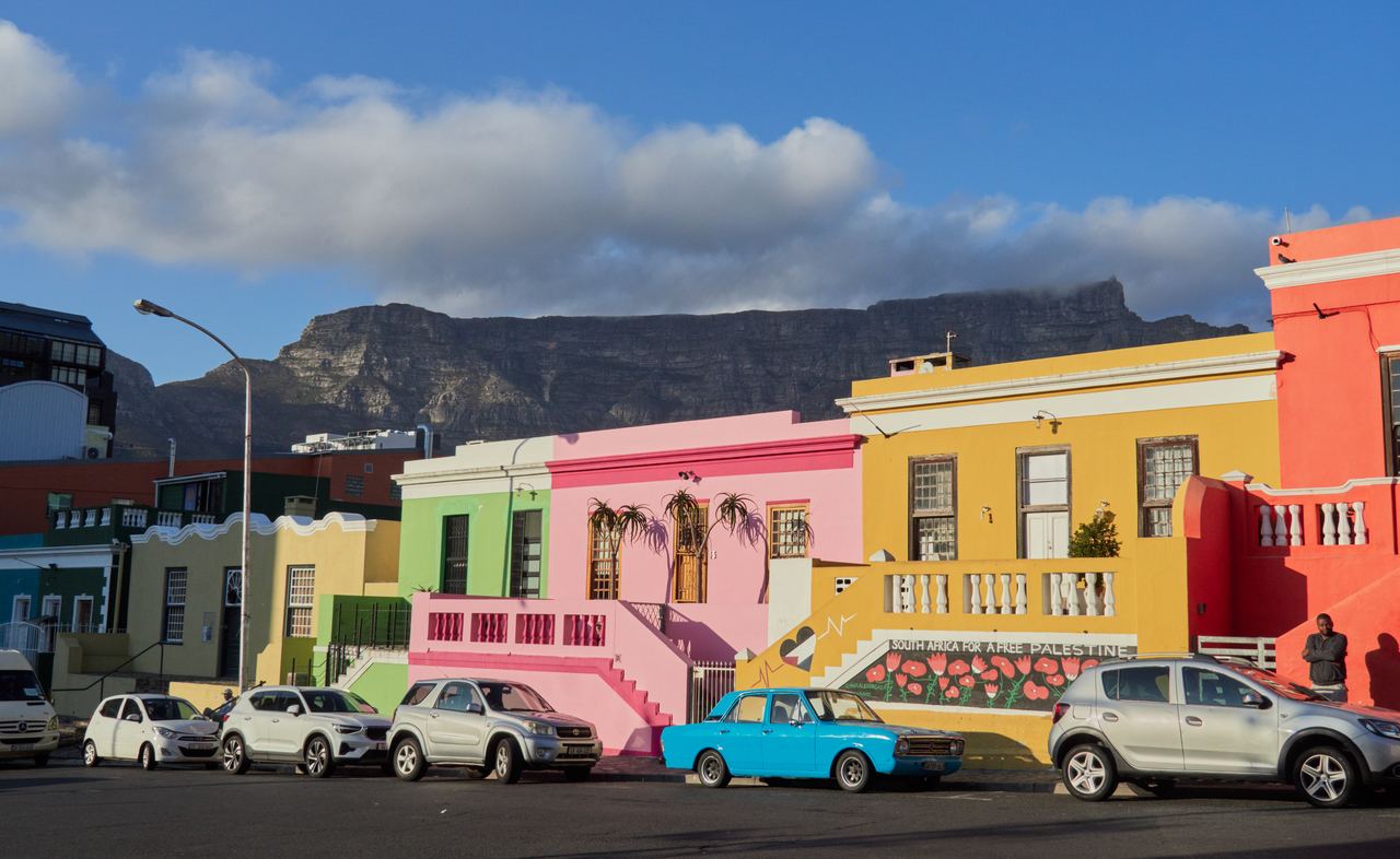 Colorful houses line a street in Bo-Kaap with Table Mountain behind, Cape Town, South Africa